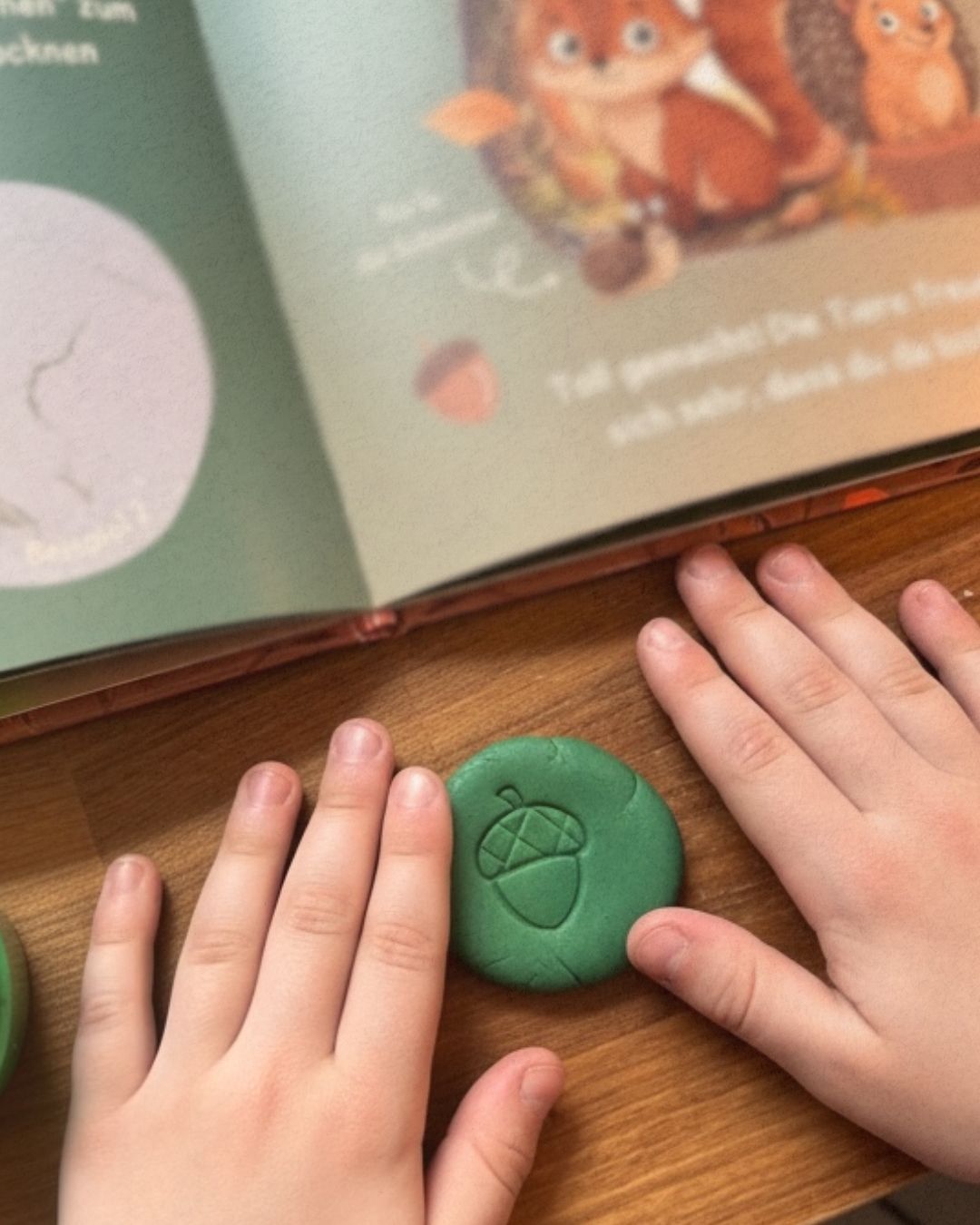 Kinderhände kneten mit der Zendou Kids Waldbox – Mitmachbuch im Hintergrund aufgeschlagen