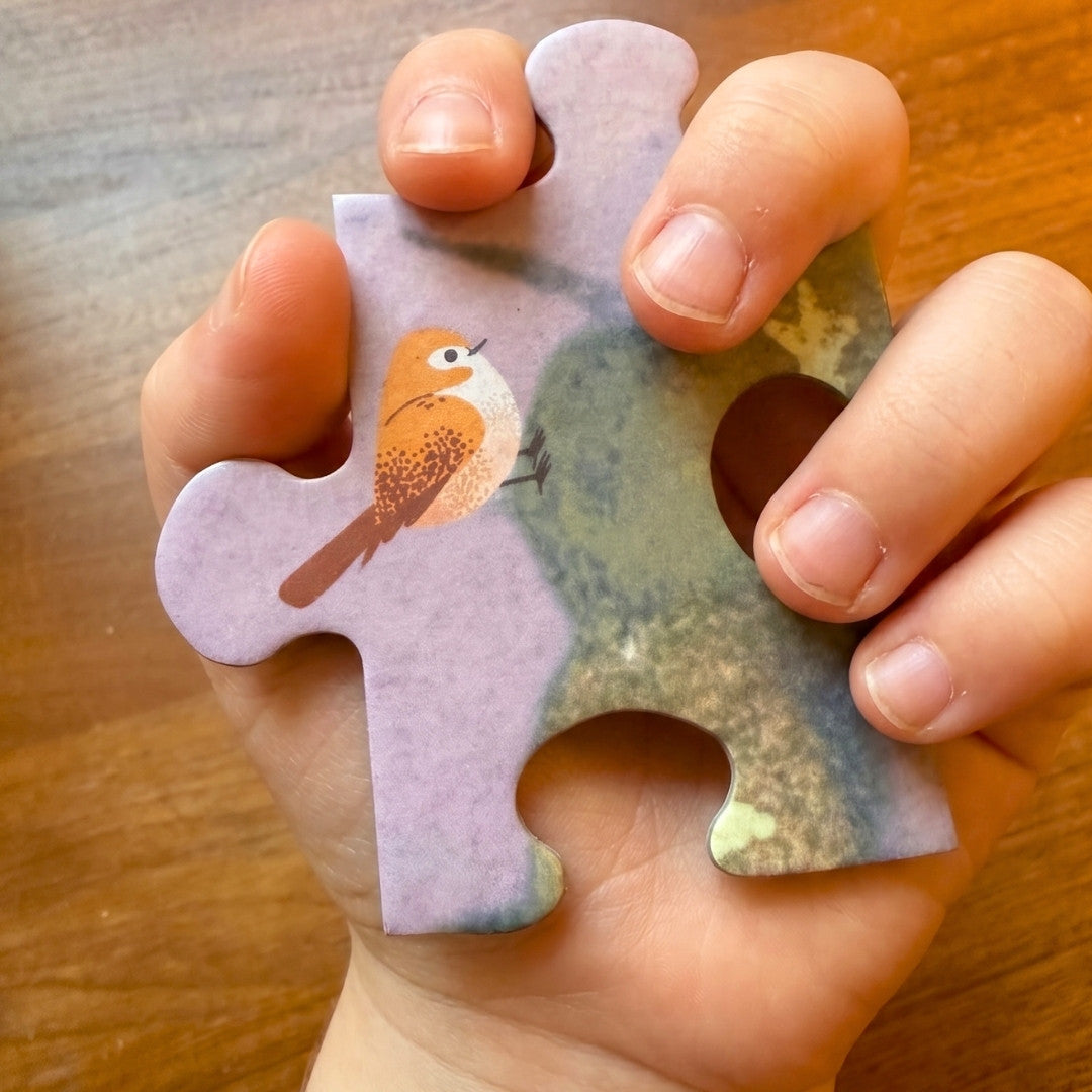 Kinderhand hält großes Puzzleteil mit Vogelmotiv – Zendou Kids Waldpuzzle wunderschöne Farben