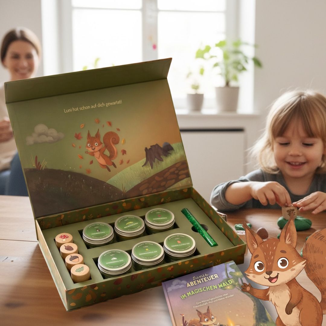 Kind spielt mit geöffneter Zendou Kids Waldbox am Tisch – Mutter lächelt im Hintergrund, Mitmachbuch und Luni sichtbar